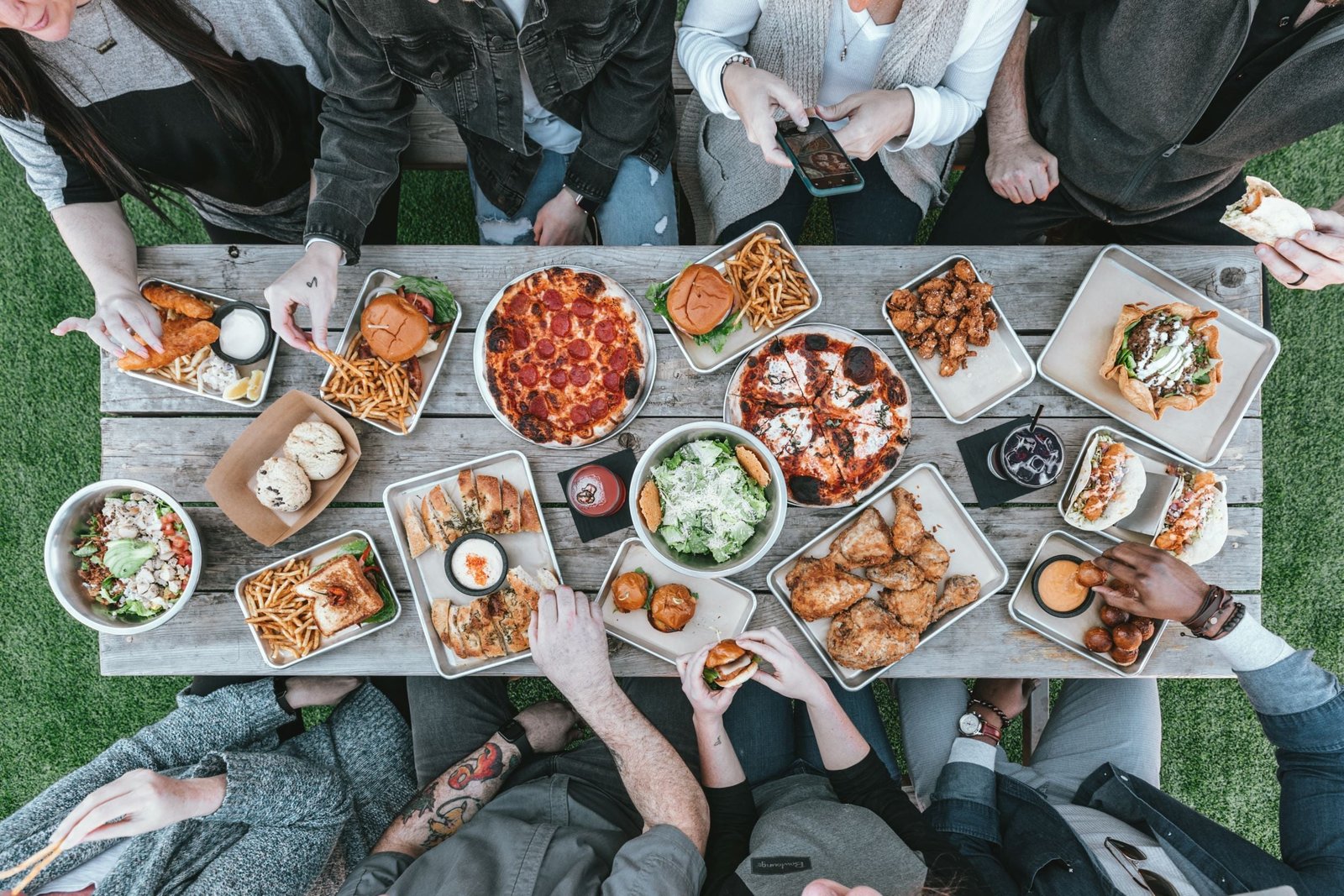 Long table of food with people ready to eat